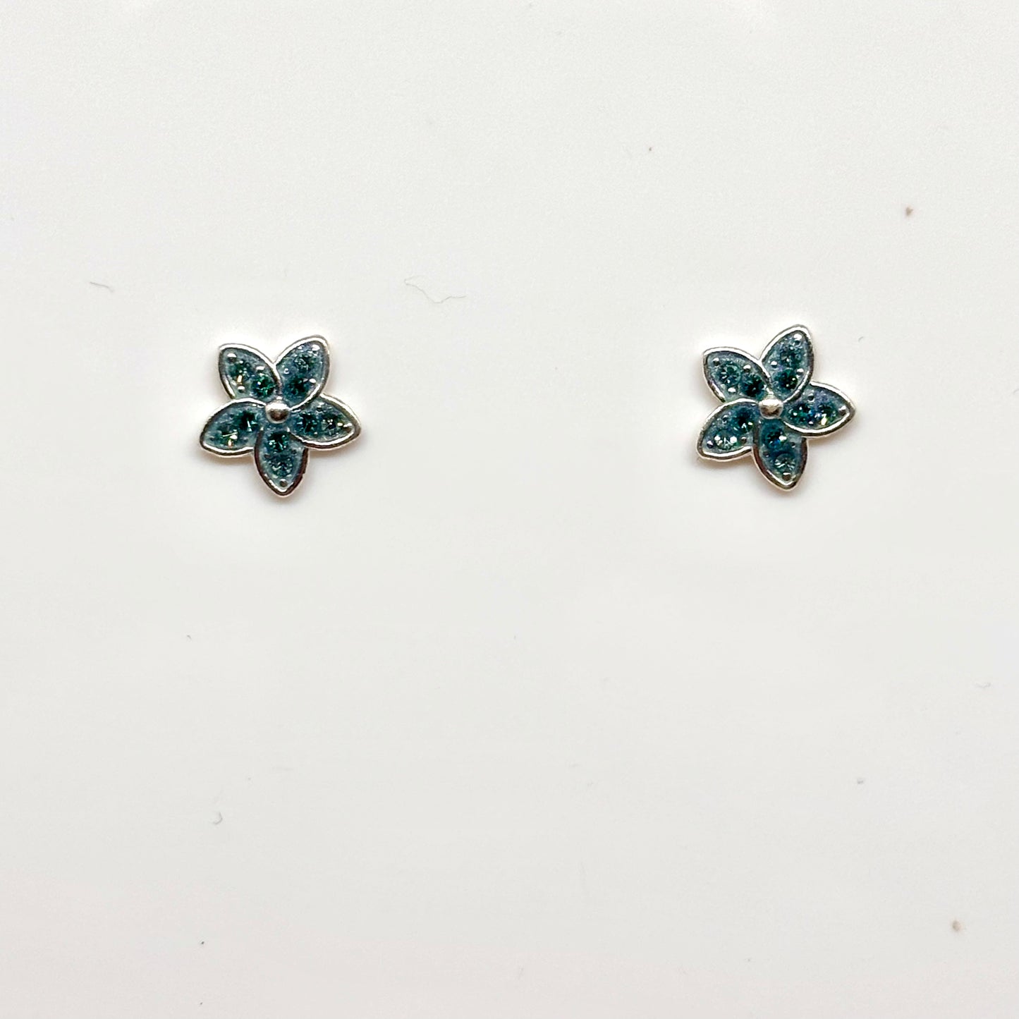 Pair of flower-shaped earrings with light blue gemstones from Pixi Daisy