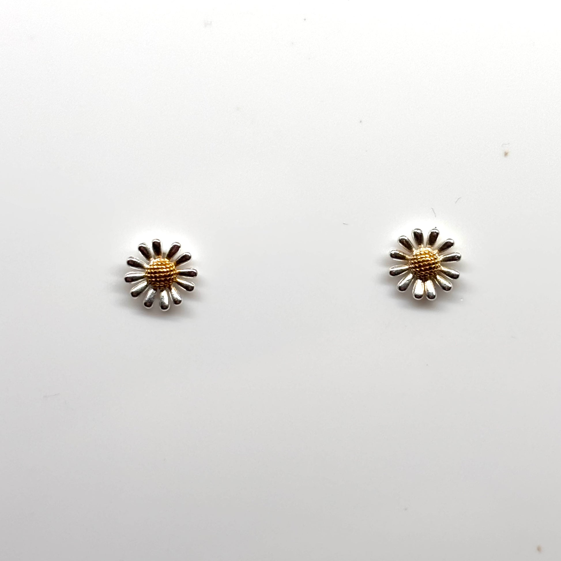 Pair of silver and gold flower-shaped earrings from Pixi Daisy